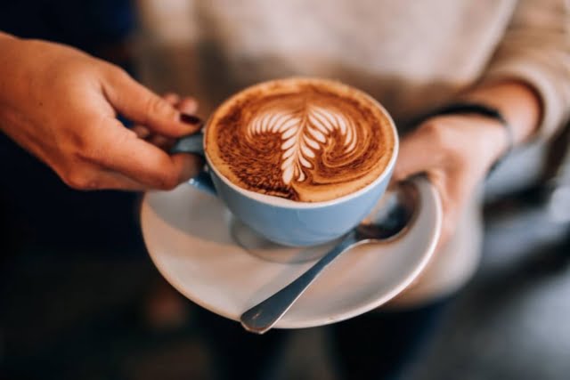10 Foods to Cure Erectile Dysfunction Permanently 7 woman holds cup saucer with hot latte coffee